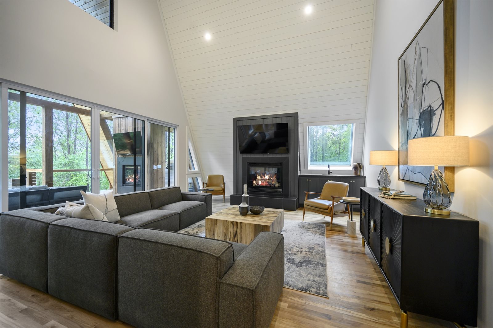Vaulted great room with big windows and a fireplace